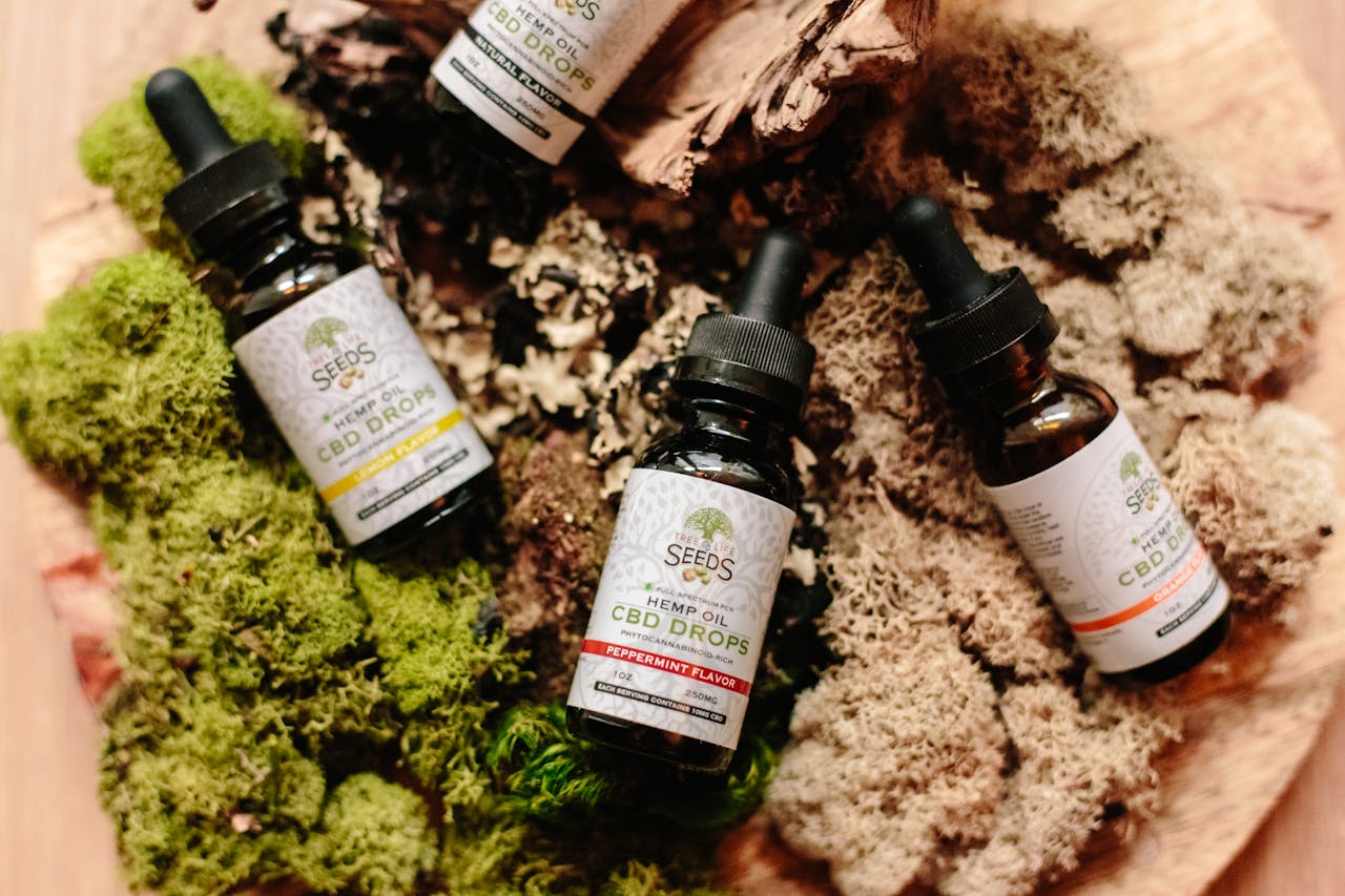 heros-img CBD oil bottles with droppers placed on a lush moss surface for organic product showcase.