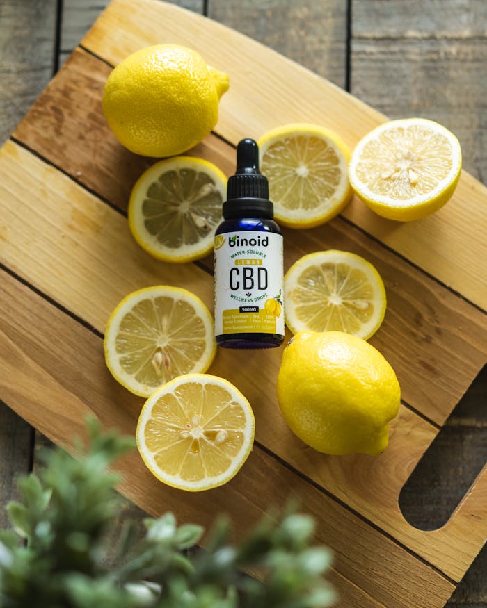 services-01 Top view of sliced fresh lemons surrounding a bottle of CBD oil on a rustic wooden board.